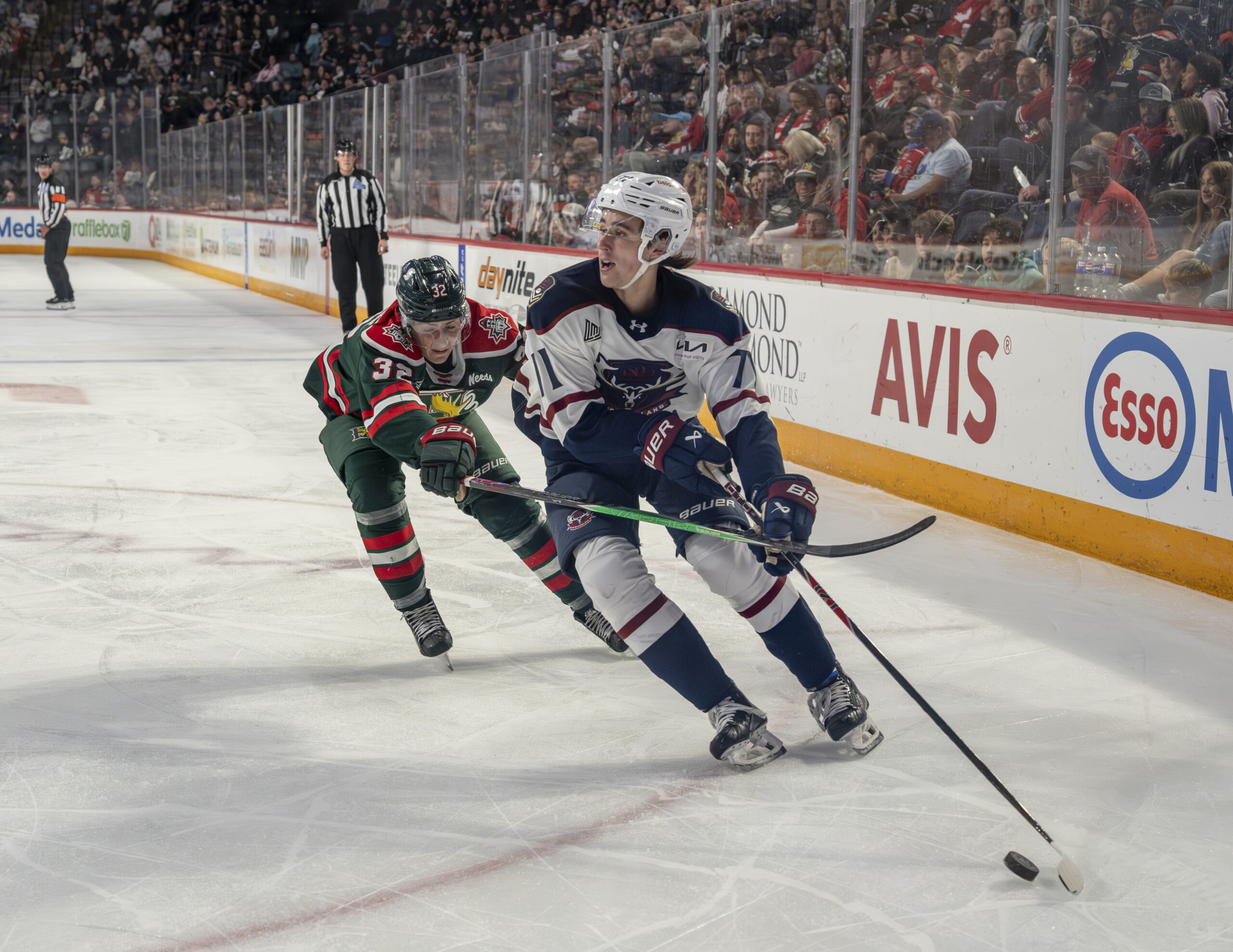 Halifax Mooseheads forward turning up ice along the boards while pressured by Newfoundland Regiment defender during QMJHL game in Halifax