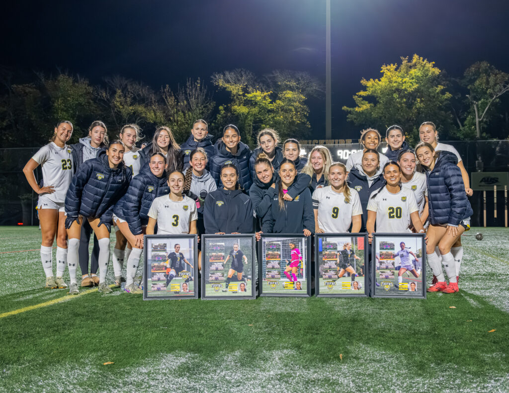 Dalhousie Tigers women's soccer seniors pose with teammates and commemorative framed photos before their final home game of the AUS season.