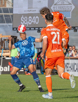 Halifax Wanderers FC player wins an aerial challenge against Forge FC during a Canadian Premier League (CPL) match in Halifax, Nova Scotia.